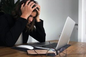 Woman looking at her laptop, feeling stressed